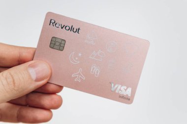 Paris, Fransa - 23 Şubat 2025: Modern bankacılık ve dijital ödeme hizmetlerinin sergilendiği kişiselleştirilmiş pembe Revolut banka kartı.
