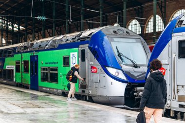 Paris, Fransa - 23 Şubat 2025: Çift katlı TER Hauts-de-France bölgesel tren platformda, modern mavi ve yeşil SNCF vagon logosu, toplu taşıma