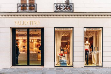 Paris, Fransa - 23 Şubat 2025: Saint-Honore sokağında Valentino butiği, altın logolu taş cephe, el çantaları ve mankenlerle vitrinler
