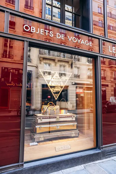 Paris, Fransa - 23 Şubat 2025: Saint-Honore sokağındaki Moynat butik vitrini, imzalı monogram ve renkli deri aksesuarlı lüks seyahat çantası