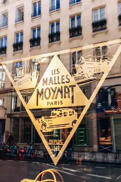 Paris, Fransa - 23 Şubat 2025: Saint-Honore sokağındaki Moynat butik vitrini, imzalı monogram ve renkli deri aksesuarlı lüks seyahat çantası