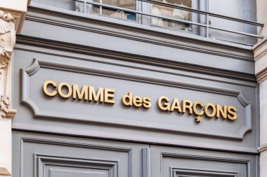 Paris, Fransa - 23 Şubat 2025: Saint Honore sokağındaki Comme des Garcons butik cephesi, klasik mimari, altın logo