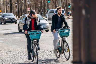 Paris, Fransa - 23 Şubat 2025: İnsanlar kaldırım taşı caddesinde bisiklet sürüyor, arabalar ve Champs Elysees 'de trafik, Paris şehir yaşam tarzı