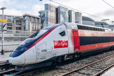 Paris, Fransa - 26 Şubat 2025: Modern yüksek hızlı TGV Lyria treni tren istasyonunda, Fransa Suisse markalı kırmızı ve beyaz vagonlar