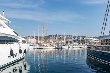 Cannes, Fransa - 8 Mart 2025: Arka planda Palais des Festivals ve şehir tepeleriyle Eski Liman 'da balıkçı tekneleri ve yatlar.