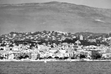 Cannes şehrinin panoramik manzarası ve Sainte-Marguerite Adası 'ndan dağlar.