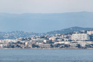 Cannes şehrinin panoramik manzarası ve Sainte-Marguerite Adası 'ndan dağlar.