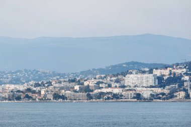 Cannes şehrinin panoramik manzarası ve Sainte-Marguerite Adası 'ndan dağlar.