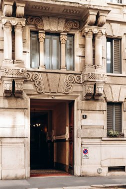 Milan, İtalya - 19 Mart 2025: Tarihi binalar, dükkanlar ve scooterlarla Merkez Milan Caddesi