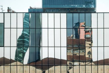 Milan, İtalya - 19 Mart 2025: Bozuk şehir manzarası Fondazione Prada Torre 'den bakıldığında modern bir binanın cam cephesine yansıdı