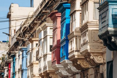 Geleneksel Malta ahşap balkonları kireçtaşı cephelerine canlı renklerle boyanmış, tipik tarihi şehir merkezi mimarisi..