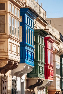 Geleneksel Malta ahşap balkonları kireçtaşı cephelerine canlı renklerle boyanmış, tipik tarihi şehir merkezi mimarisi..