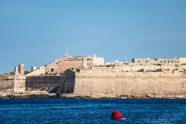 Manoel Adası 'ndaki tarihi kireçtaşı kalesi Sliema' dan, mavi Akdeniz 'den, tarihi eser, bahar günışığı