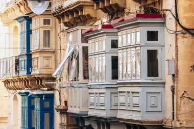 Geleneksel Malta ahşap balkonları kireçtaşı cephelerine canlı renklerle boyanmış, tipik tarihi şehir merkezi mimarisi..