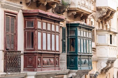 Geleneksel Malta ahşap balkonları kireçtaşı cephelerine canlı renklerle boyanmış, tipik tarihi şehir merkezi mimarisi..