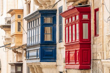 Geleneksel Malta ahşap balkonları kireçtaşı cephelerine canlı renklerle boyanmış, tipik tarihi şehir merkezi mimarisi..