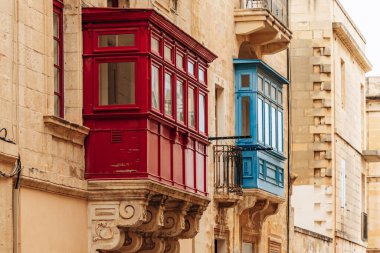 Geleneksel Malta ahşap balkonları kireçtaşı cephelerine canlı renklerle boyanmış, tipik tarihi şehir merkezi mimarisi..