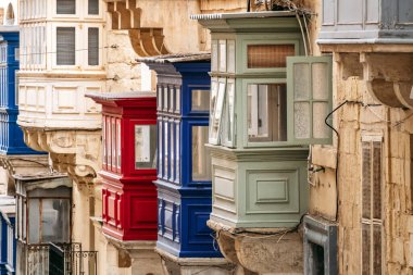 Geleneksel Malta ahşap balkonları kireçtaşı cephelerine canlı renklerle boyanmış, tipik tarihi şehir merkezi mimarisi..