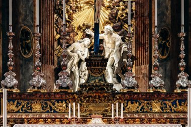 Valletta, Malta - 10 Nisan 2025: Dramatik mermer heykeller, yaldızlı vatozlar, zengin gümüş şamdanlar, koyu haç ve karmaşık altın ve mavi detaylar içeren süslü Barok sunağı