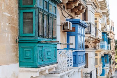 Geleneksel Malta ahşap balkonları kireçtaşı cephelerine canlı renklerle boyanmış, tipik tarihi şehir merkezi mimarisi..