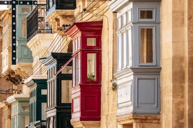 Geleneksel Malta ahşap balkonları kireçtaşı cephelerine canlı renklerle boyanmış, tipik tarihi şehir merkezi mimarisi..