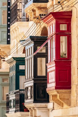 Geleneksel Malta ahşap balkonları kireçtaşı cephelerine canlı renklerle boyanmış, tipik tarihi şehir merkezi mimarisi..