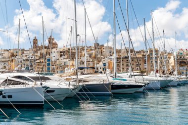 Senglea ve Birgu arasındaki geleneksel Malta rıhtım binalarının ve renkli balkonların manzarası güneşli bir baharda marinada demirlemiş tekne ve yatlarla
