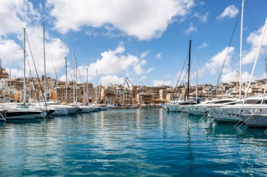 Senglea ve Birgu arasındaki geleneksel Malta rıhtım binalarının ve renkli balkonların manzarası güneşli bir baharda marinada demirlemiş tekne ve yatlarla