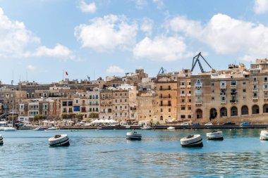 Grand Harbor 'daki rıhtım binaları sakin sularda yüzen şamandıralarla dolu.