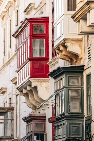 Geleneksel Malta ahşap balkonları kireçtaşı cephelerine canlı renklerle boyanmış, tipik tarihi şehir merkezi mimarisi..