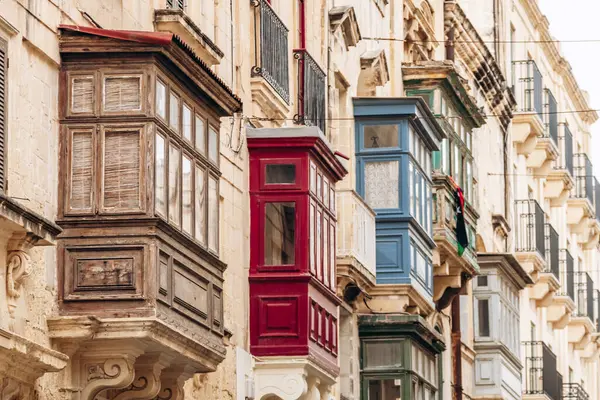Geleneksel Malta ahşap balkonları kireçtaşı cephelerine canlı renklerle boyanmış, tipik tarihi şehir merkezi mimarisi..