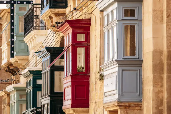 Geleneksel Malta ahşap balkonları kireçtaşı cephelerine canlı renklerle boyanmış, tipik tarihi şehir merkezi mimarisi..