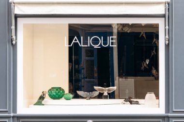 Paris, Fransa - 7 Eylül 2025: Paris 'teki Rue Royale' de Lalique butiğinin vitrininde temiz bir pencerenin arkasında zarif kristal parçalar sergileniyor.
