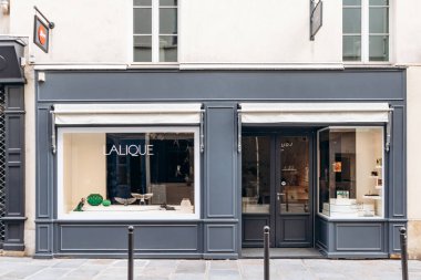 Paris, Fransa - 7 Eylül 2025: Paris 'teki Rue Royale' de Lalique butiğinin vitrininde temiz bir pencerenin arkasında zarif kristal parçalar sergileniyor.