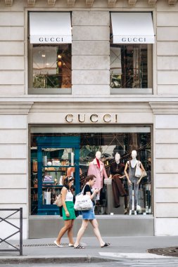 Paris, Fransa - 7 Eylül 2025: Rue Royale, Paris 'teki Gucci butiğinin cephesi, vitrininde en son koleksiyonda giydirilmiş mankenler, sokakta yürüyen insanlar.