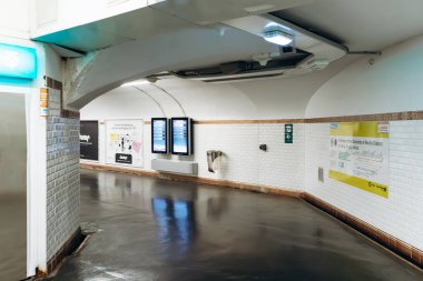 Paris, Fransa - 7 Eylül 2025: Beyaz kiremitli duvarları, dijital bilgi ekranları, reklamları ve yön işaretleriyle Paris Metro 'nun içindeki koridor