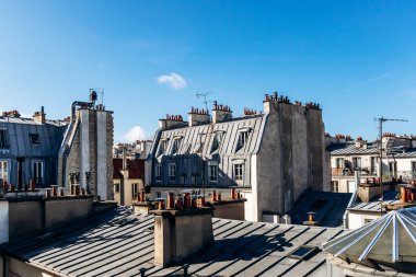Classic Paris rooftops with chimneys and mansard windows