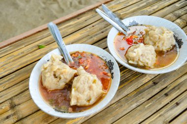 Lezzetli İki Mie Pentol Bakso mu yoksa çatal ve kaşıkla beyaz kasede köfte çorbası mı? Bir Bakso Endonezyalısının iki geleneksel yiyeceği. Köfteye, gürültüye, teşhir ve benzerlerine odaklan.