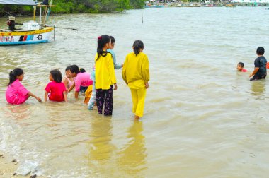 Lamongan-Endonezya, 13 Aralık 2024: Pantai Putri Klayar 'da tatilde olan çocuklar yüzüyor, kumsalda kumla oynuyor. Çocuklara odaklan, Gürültülü, teşhir, benzerleri