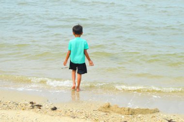 Lamongan-Endonezya, 13 Aralık 2024: Pantai Putri Klayar 'da tatilde olan çocuklar yüzüyor, kumsalda kumla oynuyor. Çocuklara odaklan, Gürültülü, teşhir, benzerleri