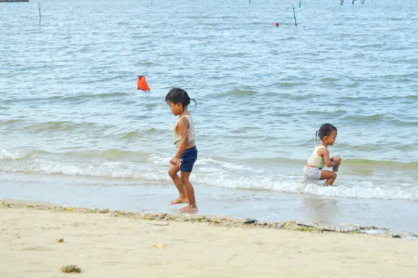 Lamongan-Endonezya, 13 Aralık 2024: Pantai Putri Klayar 'da tatilde olan çocuklar yüzüyor, kumsalda kumla oynuyor. Çocuklara odaklan, Gürültülü, teşhir, benzerleri