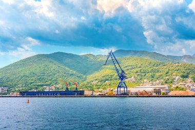 Kotor, Karadağ - 10 Ağustos 2023: Adriyatik Denizi kıyısındaki liman vinci, dağların arka planına karşı. Karadağ, Kotor Körfezi