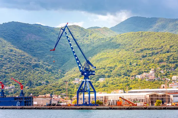 Kotor, Karadağ - 10 Ağustos 2023: Adriyatik Denizi kıyısındaki liman vinci, dağların arka planına karşı. Karadağ, Kotor Körfezi