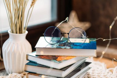 Siyah bardaklar kitapların üzerinde yatar, sabah ışığı, hafif kompozisyon, makrome, bir fincan çay