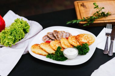 Ekşi kremalı hamur köftesi ve bir tabak et, bir restoran yemeği, patates gözlemesi, patates gözlemesi, hashbrowns 