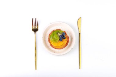 Çatal ve bıçak beyaz arka planda bir plaka ile.