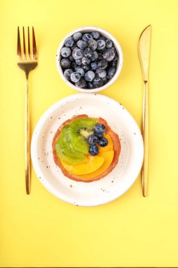 Yaban mersinli lezzetli krepler ve renkli tabakta nane yaprakları.