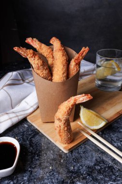 Siyah arka planda soslu kızarmış karides ve karides. deniz ürünleri.