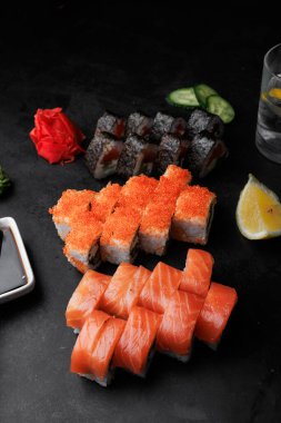 Siyah taştan bir arka planda taze suşi, Japon yemeği, suşi, somon, saşimi, zencefil, suşi..
