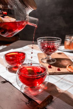 Siyah arka planda çaydanlık olan bir fincanda çay